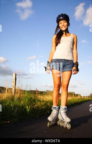 Donna su pattini a rotelle in linea in una calda serata di sole. Da Aarhus, Danimarca. Foto Stock