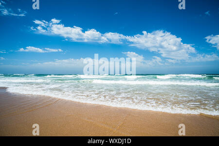 Giallo sabbia spiaggia, il mare e il profondo blu del cielo. Foto Stock