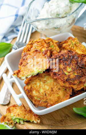 Frittelle di zucchini in una piccola pentola di bianco. Foto Stock