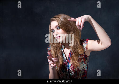 Cool rocker country girl con lunghi sporco-capelli biondi e un atteggiamento Foto Stock