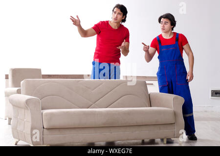Due giovani contraente i dipendenti che si spostano oggetti personali Foto Stock