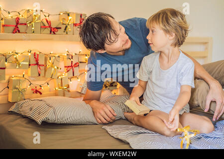 Papà si sveglia ragazzino della mattina e la casa ha fatto il calendario dell'avvento su un ripiano. In inverno la tradizione stagionale. Natale calendario dell'Avvento Foto Stock