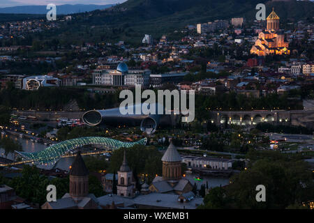 Tramonto su tbilisi illuminato con ponte di pace Foto Stock