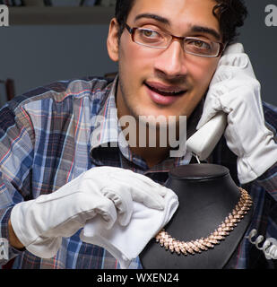 Giovane maschio gioielliere lavorando di notte nel suo laboratorio Foto Stock