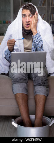 Uomo malato lavando i piedi a casa Foto Stock