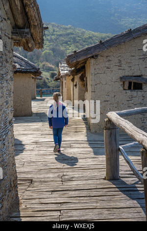 Poco ragazza camminare tra case nella baia di ossa Foto Stock