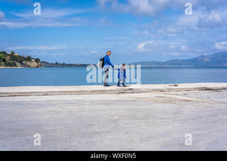 Madre e figlio camminando sulla riva del mare Foto Stock
