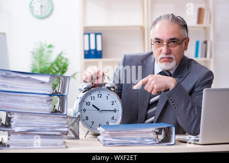 Di età compresa tra i dipendenti di sesso maschile infelice con un eccessivo lavoro Foto Stock