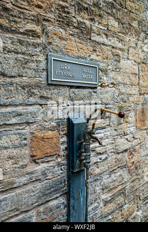 Toccare la fornitura di acqua santa di un bene a Holywell in Denbighshire, il Galles del Nord Foto Stock