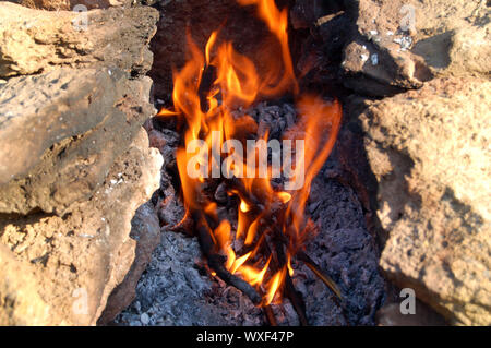 Orange lingue di fiamma sulla natura tra la pietra Foto Stock