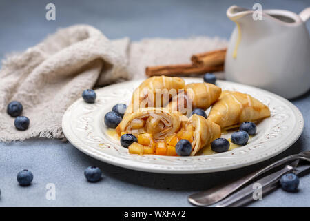 Crepes con ripieno di mele, mirtillo e salsa di caramello. Foto Stock