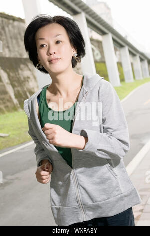 Esecuzione di sport donna matura di asiatici, closeup ritratto al parco in ore diurne. Foto Stock