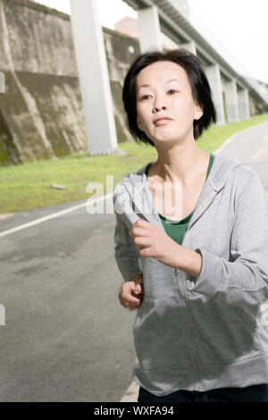 Esecuzione di sport donna matura di asiatici, closeup ritratto al parco in ore diurne. Foto Stock