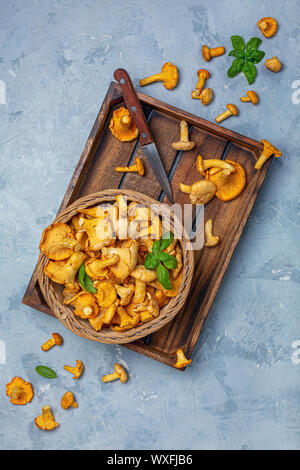 Foresta di funghi finferli in un cesto di vimini. Foto Stock