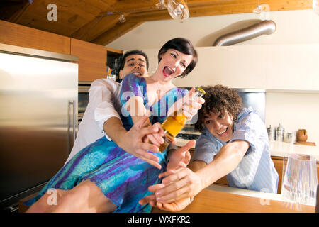 La vita domestica: amici in lizza per l'ultima birra Foto Stock