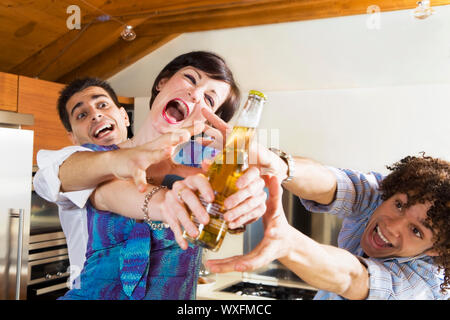 La vita domestica: amici in lizza per l'ultima birra Foto Stock