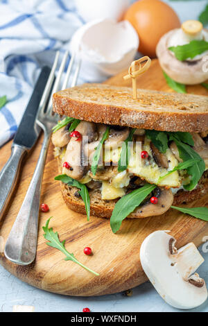 Pane tostato panino con funghi e uova strapazzate. Foto Stock