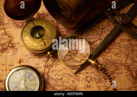 Vecchio orologio con bussola e tubazione di vergognoso giacente sulla mappa cartacea Foto Stock