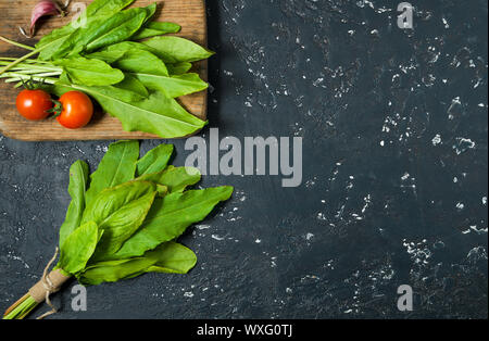 Green sorrel. Fresh sorrel lascia su di una superficie scura. Vista da sopra. Spazio di copia Foto Stock