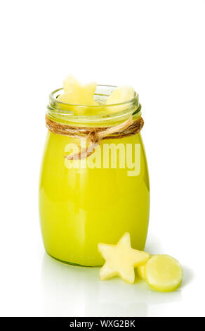 Giallo fresco i frullati di frutta fresca figurine sulle isolare. Vaso con un cocktail di vegetali decorate con frutta a stelle e cerchio Foto Stock