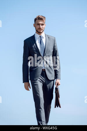 Fiducioso imprenditore con valigetta in pelle in avanti passo-passo Foto Stock