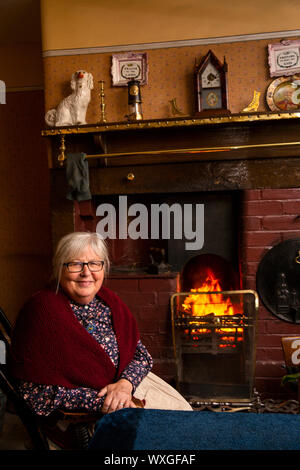 Regno Unito, County Durham, Beamish, museo, Pit Village, Francesco Street Miner's cottage, volontario in costume sat da cucina Foto Stock