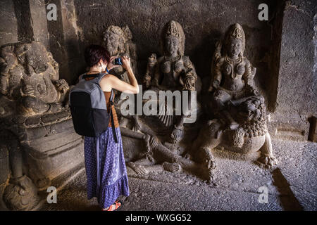 La ragazza riprese turistiche una foto su uno smartphone mentre si cammina in un tempio complesso. Kailash tempio di Ellora.India Foto Stock