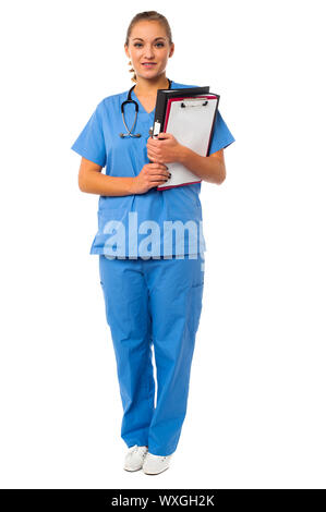 Medico donna azienda file e appunti a piena lunghezza studio shot Foto Stock