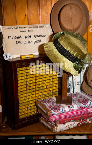 Regno Unito, County Durham, Beamish, museo, Città, Arnfield pianura Industrial Co-shop, merceria reparto, cloche cappelli sul display dal segno del dividendo Foto Stock