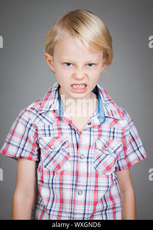 Un frustrato e arrabbiato cerca ragazzo giovane tirando una faccia. Isolato su bianco. Foto Stock