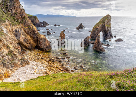 Testa Crohy arco sul mare e il mare di pile nella Contea di Donegal, Irlanda Foto Stock