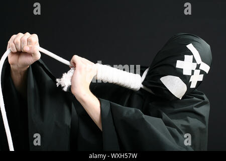 Nero con mime fune sul collo su sfondo nero Foto Stock