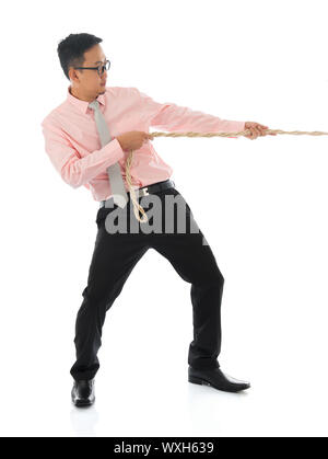 Corpo pieno Asian businessman tirando una corda , isolato su sfondo bianco. Asian modello maschile. Foto Stock