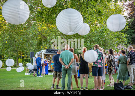 Rotterdam, Paesi Bassi. Giugno 29, 2019. Ijsvrij festival in un parco locale. Persone appendere fuori ordinare cibo e bevande a una mensa sotto gli alberi e pend Foto Stock