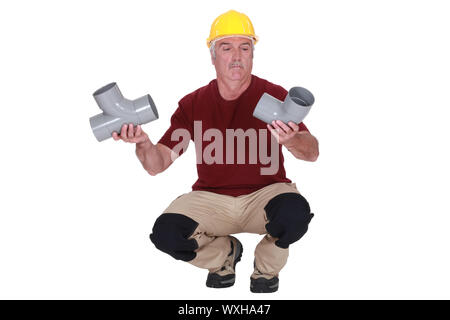 Plumber tenendo due tubi Foto Stock