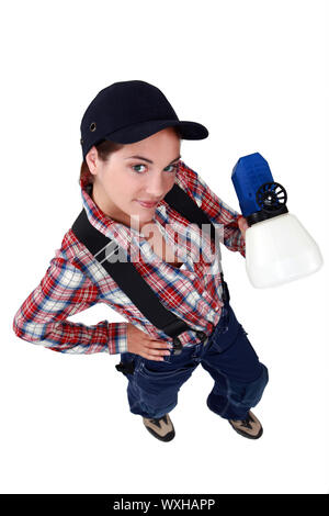 Tradeswoman tenendo una pistola a spruzzo Foto Stock