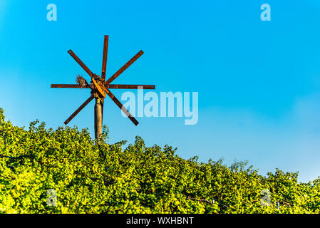 Guarda al mulino a vento sulla vigna del sud della Stiria rotta del vino in Austria nel tramonto. Glanz an der Weinstrasse. Foto Stock