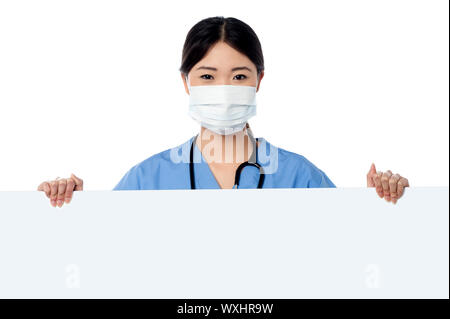 Giovani donne medico in posa da dietro una lavagna vuota. Foto Stock