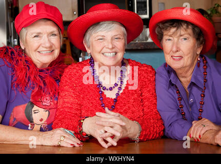 Tre simpatici senior donne che indossano il cappello rosso Foto Stock