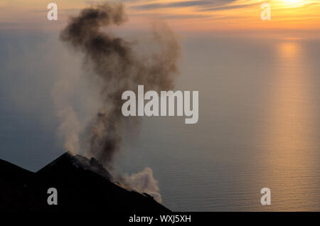 Il fumo del vulcano al tramonto sull'isola di Stromboli, Sicilia, Italia Foto Stock