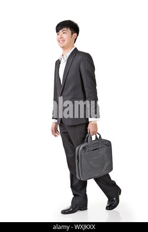 Giovane imprenditore tenere nella valigetta e camminare a piena lunghezza ritratto isolato su sfondo bianco. Foto Stock