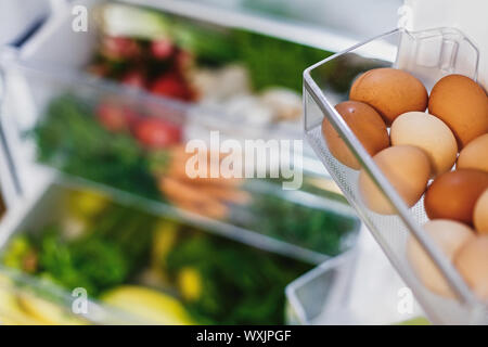 Uova di close-up di plastica e libera le carote, pomodori, funghi,banane,insalata di spinaci, sedano, mele in frigo. Rifiuti Zero a fare la spesa. Vegeta fresco Foto Stock