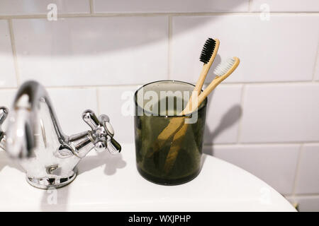 Rifiuti Zero bagno concetto. Eco di bamboo naturale spazzolini da denti in un barattolo di vetro il lavandino in bagno. Plastica articoli gratuiti. Uno stile di vita sostenibile. Hygien orale Foto Stock