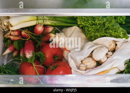 Rifiuti Zero negozio di generi alimentari in frigo. Ortaggi freschi nel cassetto aperto in frigorifero. Libero di plastica le carote, pomodori, funghi,ravanello,insalata di rucola, zero Foto Stock