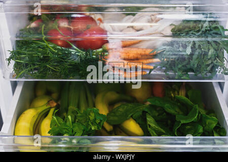 Rifiuti Zero negozio di generi alimentari in frigo. Ortaggi freschi nel cassetto aperto in frigorifero. Libero di plastica le carote, pomodori, funghi,banane,insalata di sedano, Apple Foto Stock