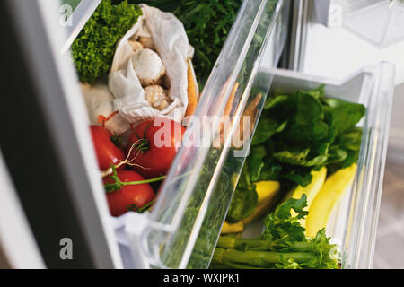 Rifiuti Zero negozio di generi alimentari in frigo. Ortaggi freschi nel cassetto aperto in frigorifero. Libero di plastica le carote, pomodori, funghi,ravanello,insalata di rucola, zero Foto Stock