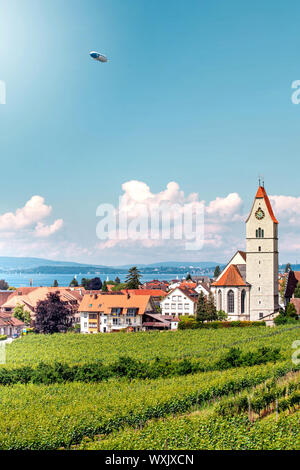 Vista panoramica del lago di Lago di Costanza. Zeppelin, meli e Chiesa cattolica Johann Baptist in Hagnau sull'immagine. Foto Stock