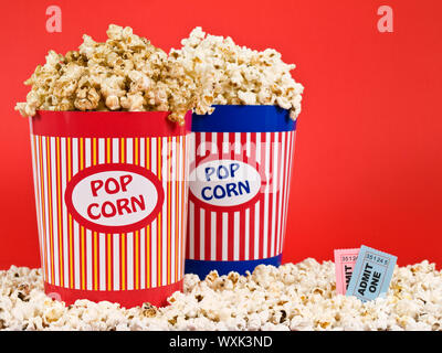 Due benne popcorn su uno sfondo rosso. Foto Stock