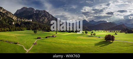 Paesaggio rurale con Neuschwanstein e Hohenschwangau castelli in distanza, Schwangau, Baviera, Germania Foto Stock