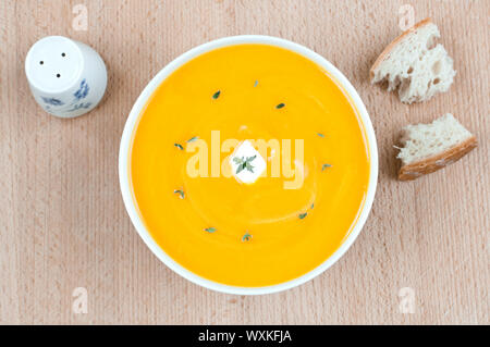 Fresca zuppa di zucca in bianco ciotola con il timo sulla parte superiore con pane e sale cantina Foto Stock